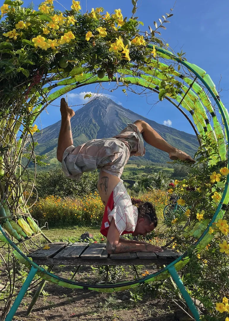 Graey doing a yoga pose in front of the Mayon volcano in the Philippines